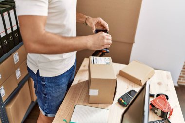 Genç İspanyol adam depoda paket etiketine fotoğraf yaptı.