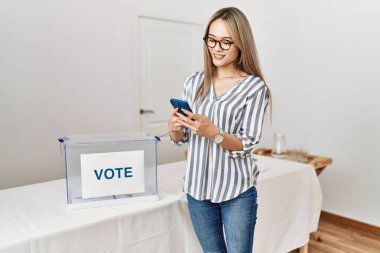Genç Çinli kadın seçmen okulunda akıllı telefon oylaması yapıyor.