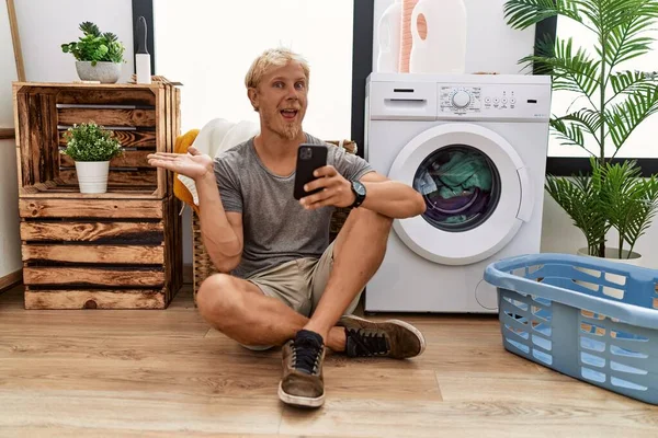 Junger Blonder Mann Wäscht Mit Smartphone Und Zeigt Mit Geöffneten — Stockfoto