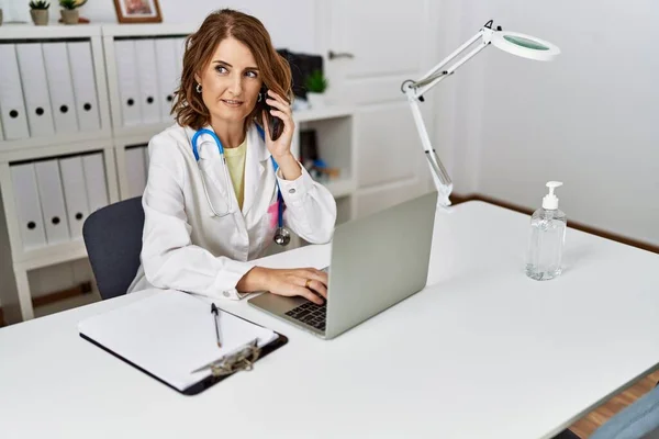 Middle Age Hispanic Woman Wearing Doctor Uniform Talking Smartphone Clinic — Stock Photo, Image
