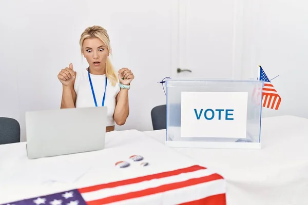 Young caucasian woman at america political campaign election pointing down with fingers showing advertisement, surprised face and open mouth