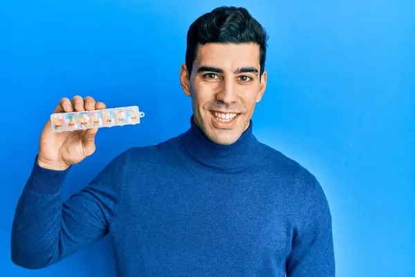 Bonito Homem Hispânico Segurando Organizador Pílula Olhando Positivo Feliz Sorrindo — Fotografia de Stock