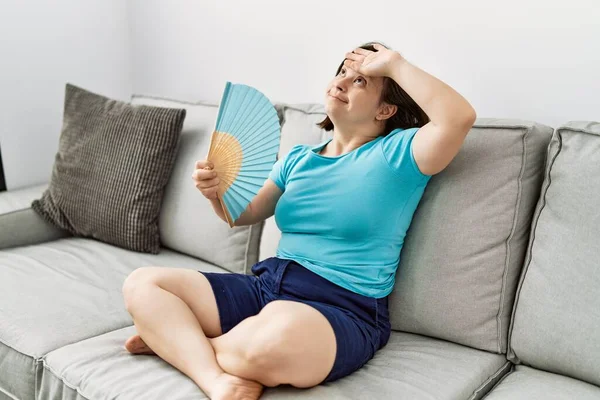 Donna Bruna Con Sindrome Seduta Sul Divano Con Ventilatore Mano — Foto Stock