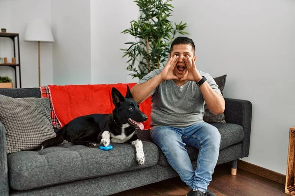 Jovem Latino Homem Cão Sentado Sofá Casa Gritando Irritado Voz — Fotografia de Stock