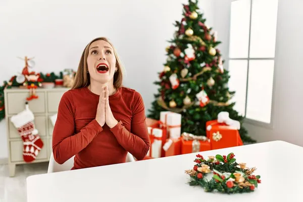 Giovane Donna Bionda Caucasica Seduta Sul Tavolo Albero Natale Implorando — Foto Stock