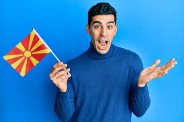 Yakışıklı, İspanyol asıllı, elinde Macaristan bayrağı olan mutlu bir gülümsemeyle zaferi kutlayan ve elini kaldıran bir adam. 