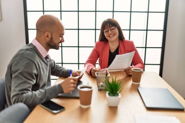 Ofiste çalışırken gülümseyen iki İspanyol iş adamı..