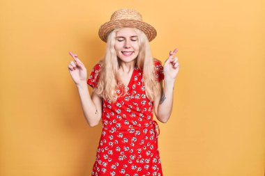 Sarı saçlı, yaz şapkası takan güzel beyaz kadın umut ve gözlerin kapalı bir şekilde gülümseyerek el sallıyor. Şans ve batıl inançlar. 