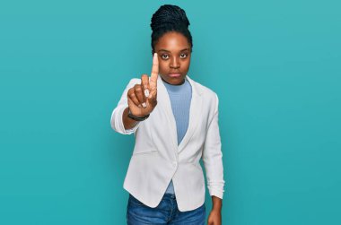 Genç Afro-Amerikan kadın iş kıyafetleri içinde parmağını kaldırmış ve kızgın bir ifadeyle işaret ediyor, hiç hareket göstermiyor. 