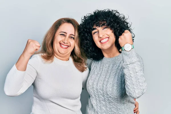 中東の母親と娘のカジュアルな服を着て非常に満足し 腕を上げて勝者のジェスチャーを行う興奮し 笑顔と成功のために叫んでいる お祝いのコンセプト — ストック写真