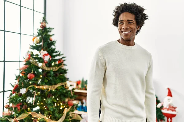 年轻的非洲裔美国人在家里站在圣诞树旁快乐地笑着 — 图库照片