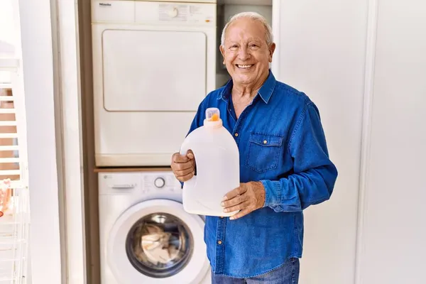Beyaz Adam Gülümsüyor Elinde Deterjan Terasta Çamaşır Makinesinin Yanında Duruyor — Stok fotoğraf