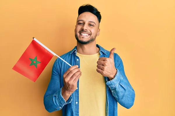 Mladý Arabský Muž Drží Morocco Vlajku Úsměvem Šťastný Pozitivní Palec — Stock fotografie