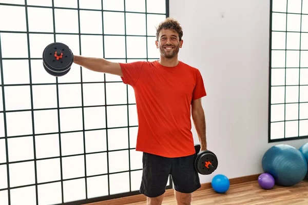 Joven Hispano Sonriendo Confiado Entrenamiento Usando Mancuernas Centro Deportivo — Foto de Stock