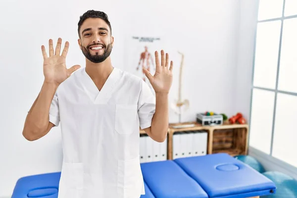 Jovem Homem Bonito Com Barba Trabalhando Clínica Recuperação Dor Mostrando — Fotografia de Stock