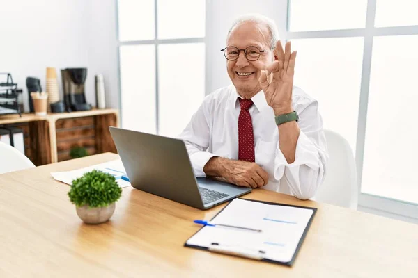 パソコンのノートパソコンを使って事務所で働く先輩が 手や指でOkサインをして笑顔で積極的にやっています 成功した表現 — ストック写真