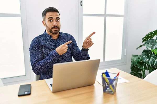 Joven Hispano Con Barba Trabajando Oficina Con Portátil Señalando Preocupado — Foto de Stock