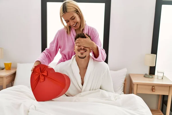 Kvinna Överraskar Sin Pojkvän Med Valentine Presentförpackning Sitter Sängen Hemma — Stockfoto