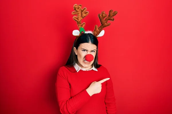 Mladá Hispánka Jelení Vánoční Čepici Červeném Nose Ukazuje Stranou Ustaraný — Stock fotografie