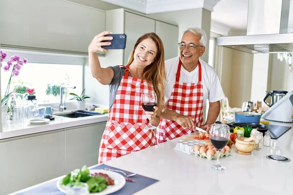 중년의 지중해 남녀가 즐거운 요리를 웃으며 부엌에 스마트폰으로 셀카를 만들고 — 스톡 사진