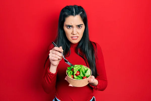 Ung Latinamerikansk Flicka Äter Sallad Ledtrådar Och Förvirrade Uttryck Tvivel — Stockfoto