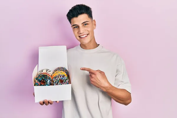 Joven Hombre Hispano Sosteniendo Caja Sabrosas Rosquillas Coloridas Sonriendo Feliz —  Fotos de Stock