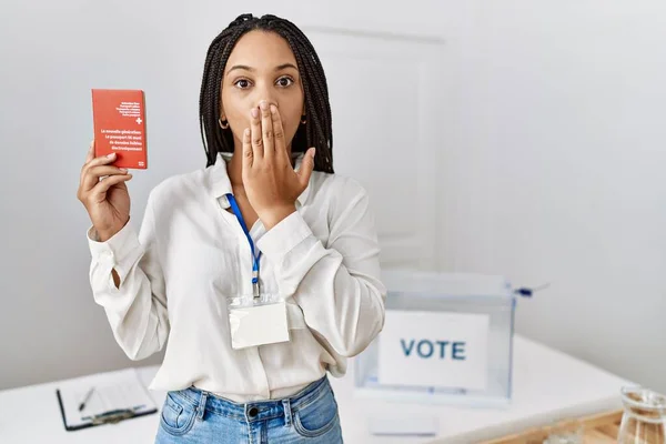 政治選挙でスイスのパスポートを手で口にした若いアフリカ系アメリカ人女性はショックを受け 間違いを恐れていた 驚きの表情 — ストック写真