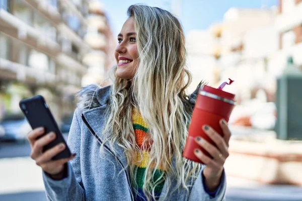 年轻的金发女人在城里用智能手机 — 图库照片