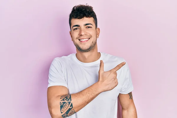 Joven Hombre Hispano Vistiendo Camiseta Blanca Casual Sonriendo Alegre Señalando —  Fotos de Stock