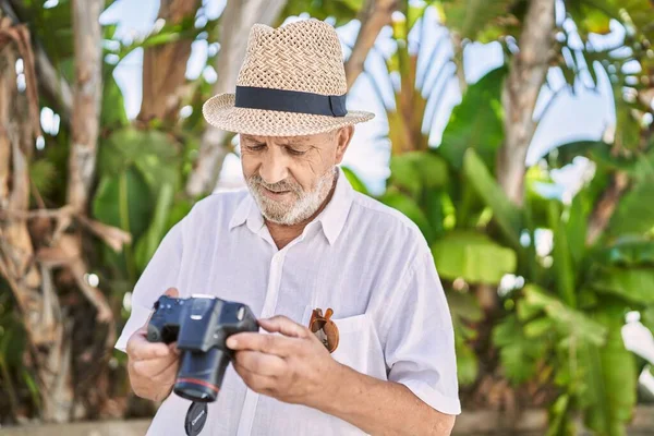 Uomo Anziano Sorridente Fiducioso Indossa Cappello Estivo Utilizzando Fotocamera Parco — Foto Stock