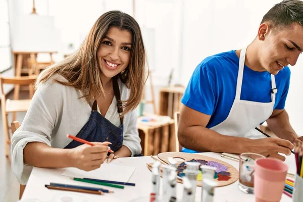 美術学校のテーブルの上で笑顔で絵を描く2人の学生 — ストック写真