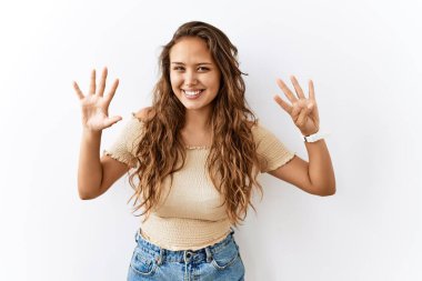 Güzel İspanyol kadın tek başına ayakta dikilirken arka plan dokuz numarayı gösterip işaret ederken kendinden emin ve mutlu bir şekilde gülümsüyor.. 