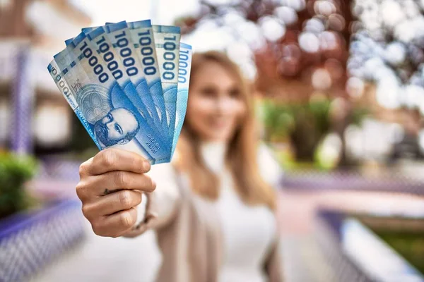 Young Blonde Woman Smiling Confident Holding Chilean Pesos Banknotes Park — Stock Fotó