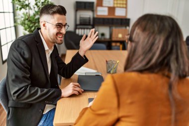 Ofiste çalışırken gülümseyen iki İspanyol iş adamı..