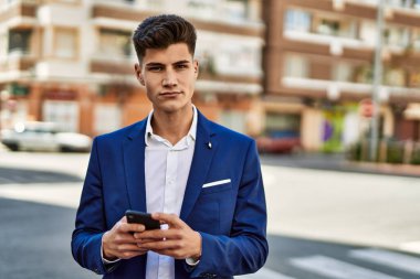 Sokakta akıllı telefon kullanan genç bir adam.