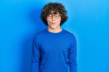 Yakışıklı genç adam günlük kıyafetler ve gözlük takıyor dudaklarıyla balık suratı yapıyor, çılgınca ve komik bir jest. Komik ifade. 