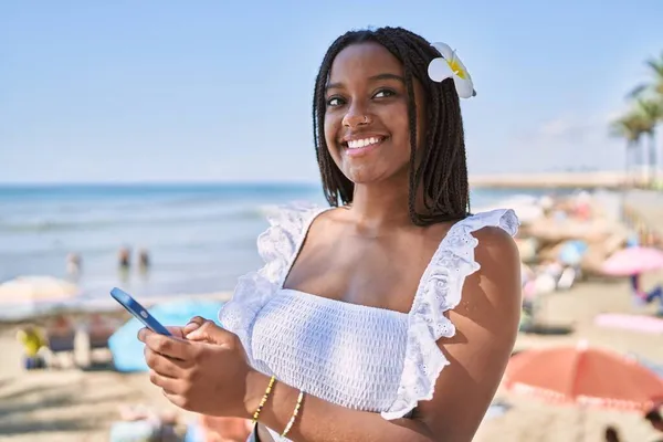 Ung Afrikansk Amerikansk Flicka Ler Glad Med Hjälp Smartphone Stranden — Stockfoto