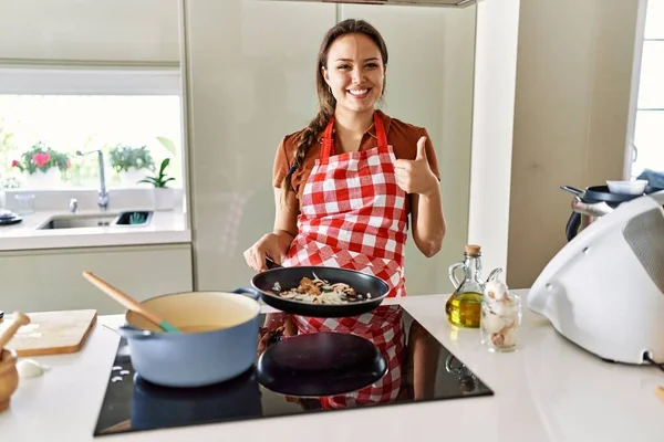 Mutfakta Önlük Giymiş Güzel Esmer Kadın Mutlu Pozitif Gülümsüyor Başparmağıyla — Stok fotoğraf