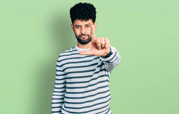 Młody Arabski Mężczyzna Brodą Noszący Luźny Sweter Paski Wskazujący Palcem — Zdjęcie stockowe