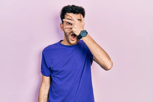 Mladý Hispánec Neformální Tričku Vykukuje Šoku Zakrývá Obličej Oči Rukou — Stock fotografie