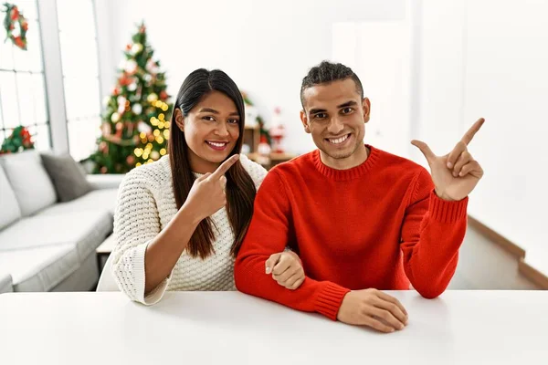 Young Latin Couple Sitting Table Christmas Tree Cheerful Smile Face — Stockfoto