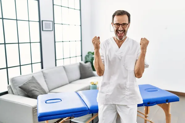 中年理学療法士仕事で自宅悲鳴誇りに思って 勝利と成功を祝う非常に興奮して腕を上げ — ストック写真