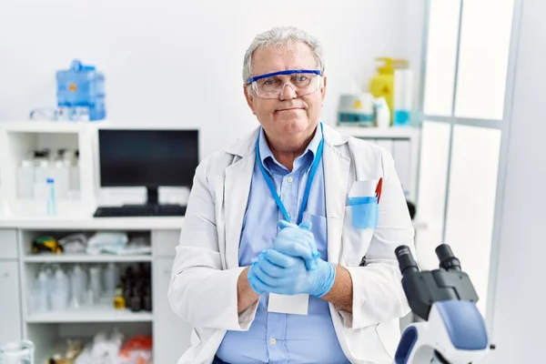 中年白髪の男笑顔自信を持って身に着けている科学者制服で研究室 — ストック写真