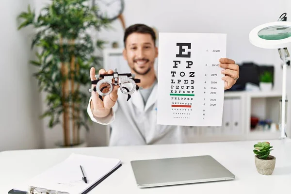 Junger Hispanischer Mann Optikeruniform Hält Schnappschuss Test Klinik — Stockfoto