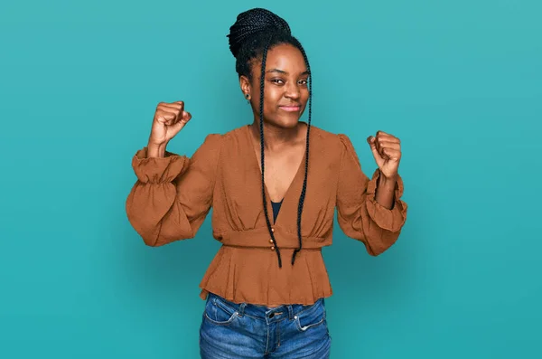 アフリカ系アメリカ人の若い女性が腕の筋肉を示すカジュアルな服を着て誇らしげに笑っている フィットネスのコンセプト — ストック写真