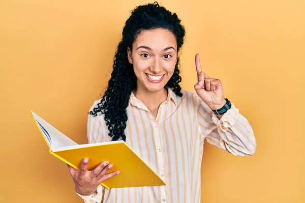 Young Hispanic Woman Curly Hair Holding Book Smiling Amazed Surprised — Stock Photo, Image