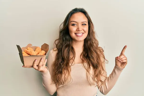 Jovem Hispânica Comendo Asas Frango Sorrindo Com Uma Ideia Pergunta — Fotografia de Stock