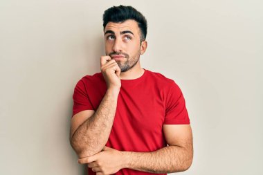 Gündelik kıyafetler giyen genç İspanyol adam şüphe üzerine yoğunlaşmıştı. Parmakları çenesinde ve yukarı bakıyordu. 