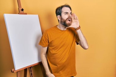 Boyacı sehpasının yanında duran beyaz sakallı adam el ele tutuşmuş bağırıyor ve çığlık çığlığa bağırıyordu. iletişim konsepti. 