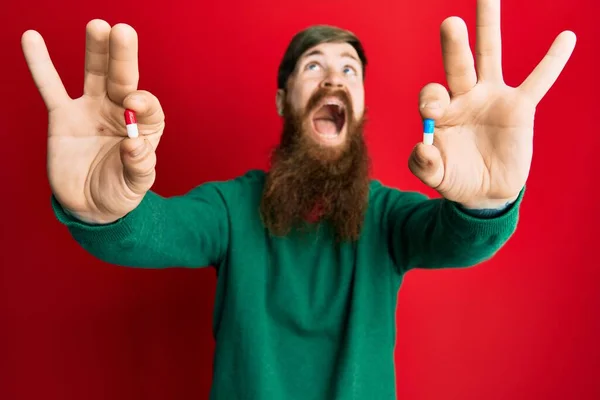 Redhead Man Long Beard Holding Two Different Pills Angry Mad — Stock Photo, Image